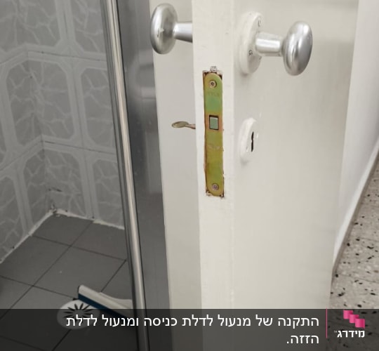 תמונת תקריב של מנגנון מנעול וידית בדלת פנים לבנה